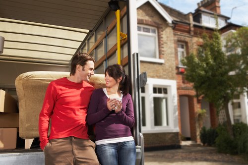 Professional movers carrying items from a flat in Willesden